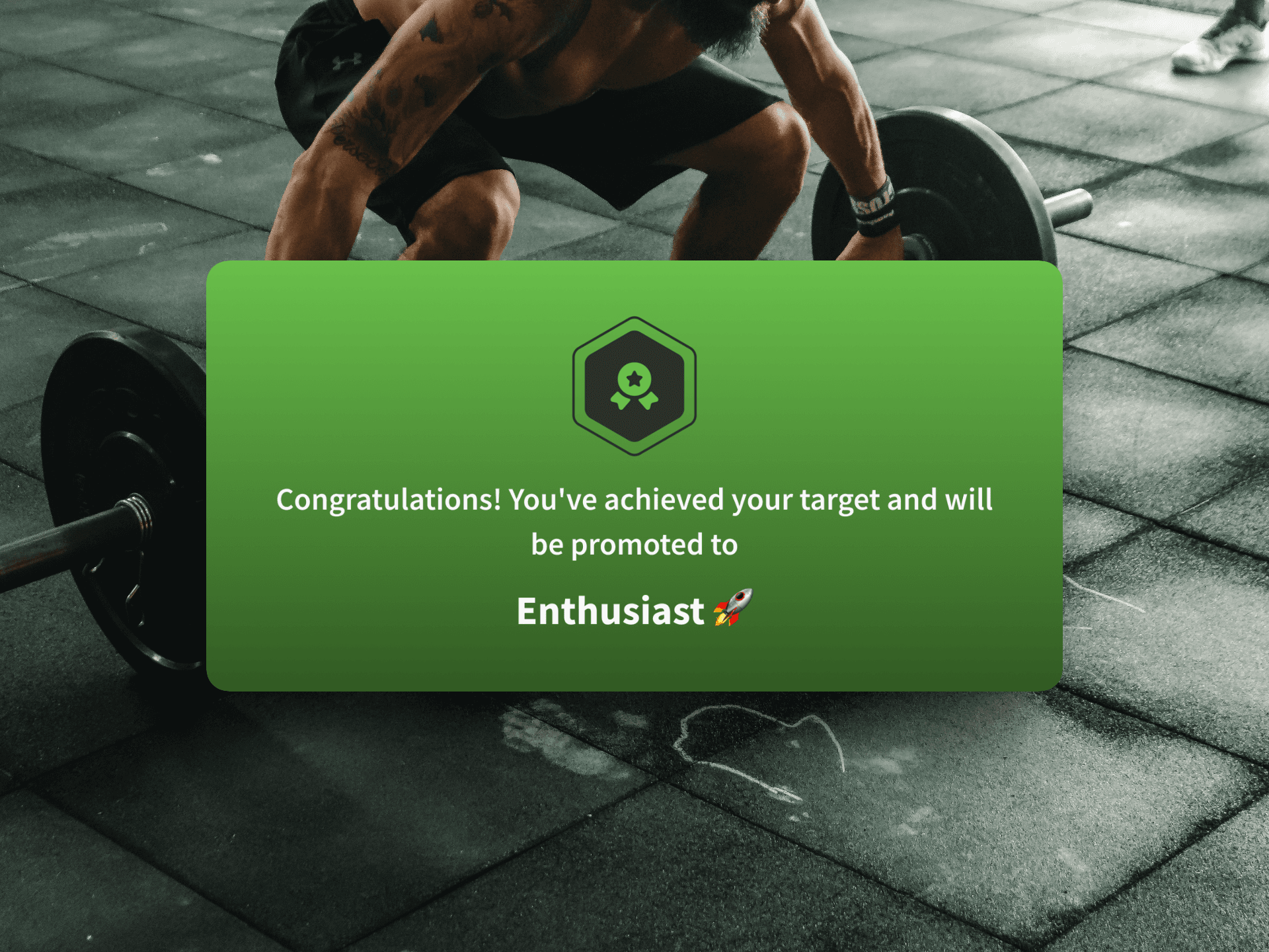 BeneFit app achievement card congratulating a user on reaching the Enthusiast tier, overlaid on a photo of gym weights.